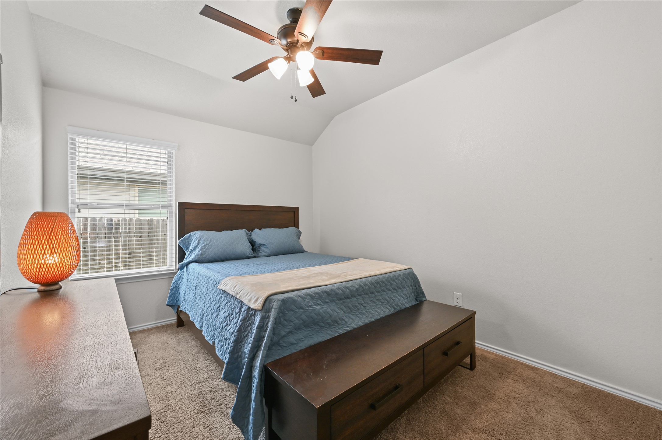 303 Limerick Road Buda, TX 78610 - Photo 15 of 23 Spacious bedroom featuring vaulted ceilings, a window with blinds, and a ceiling fan with integrated lighting