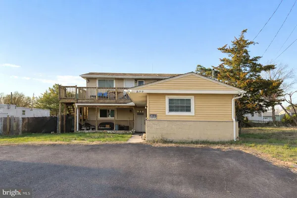 a front view of house with yard and trees in the background
