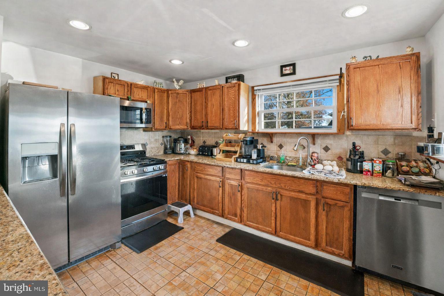 870 Downe Avenue Fortescue, NJ 08321 - Photo 6 of 26 a kitchen with stainless steel appliances granite countertop a refrigerator a sink a stove a microwave and island