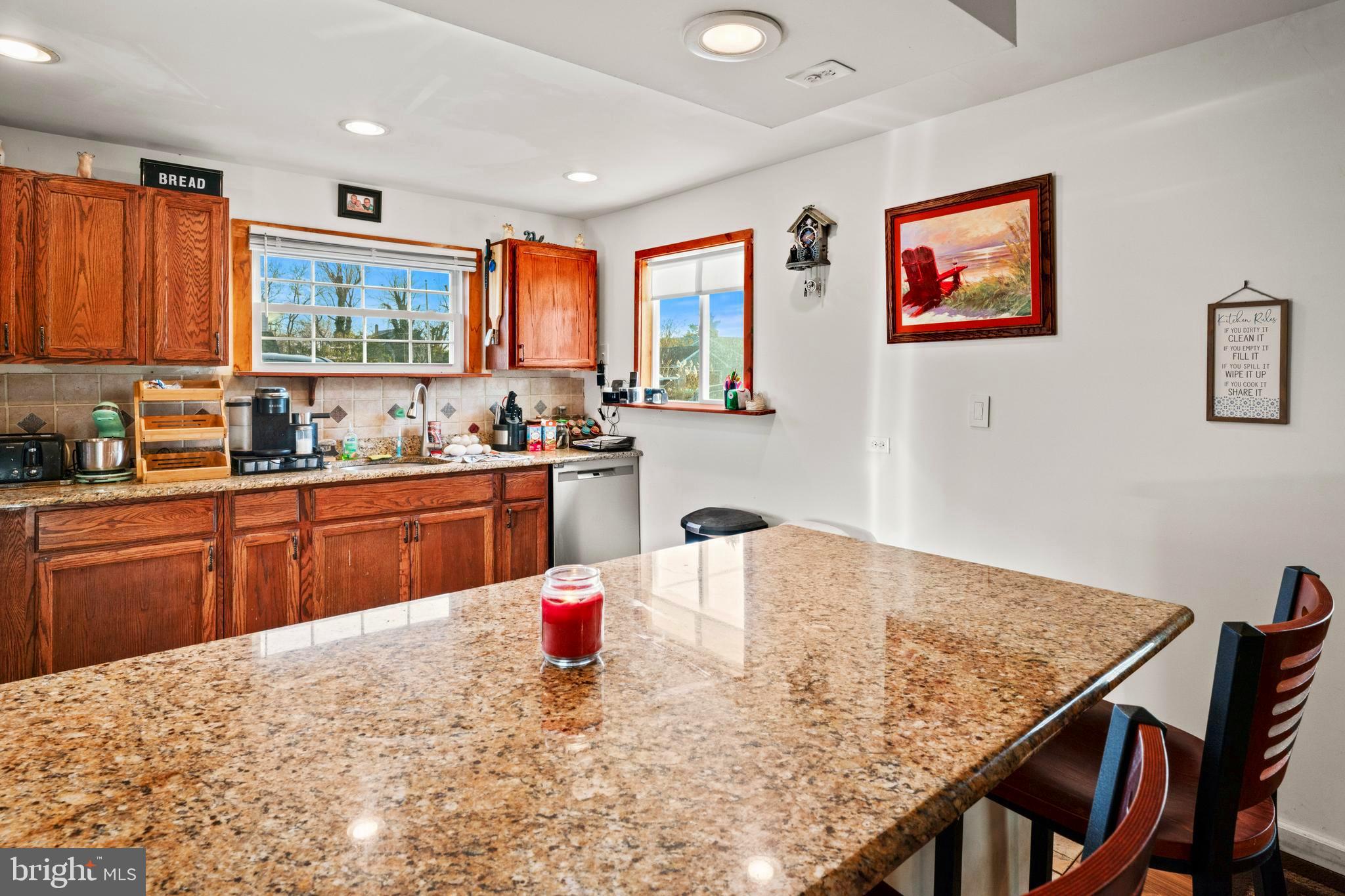 870 Downe Avenue Fortescue, NJ 08321 - Photo 7 of 26 a kitchen with stainless steel appliances granite countertop a stove a sink dishwasher a dining table and chairs with wooden floor
