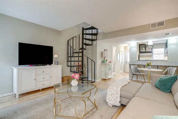 a living room with furniture a flat screen tv and kitchen view