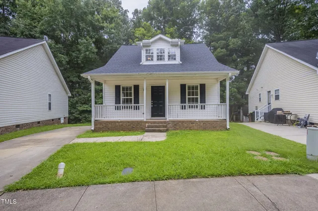a front view of a house with yard and green space