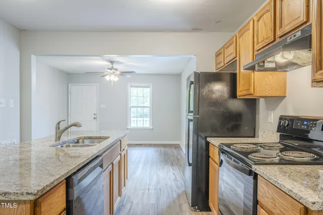 a kitchen with stainless steel appliances granite countertop a refrigerator and a sink