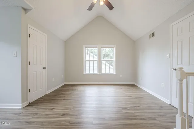 a view of a room with wooden floor and windows
