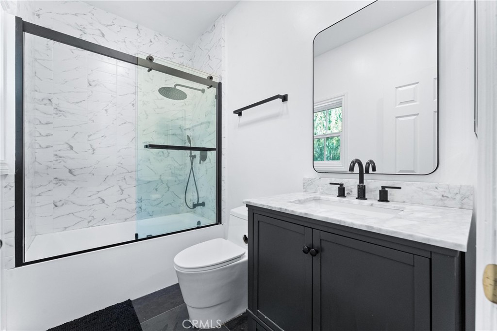927 Avocado Crest Road La Habra Heights, CA 90631 - Photo 37 of 72 a bathroom with a granite countertop sink toilet a mirror a vanity and shower