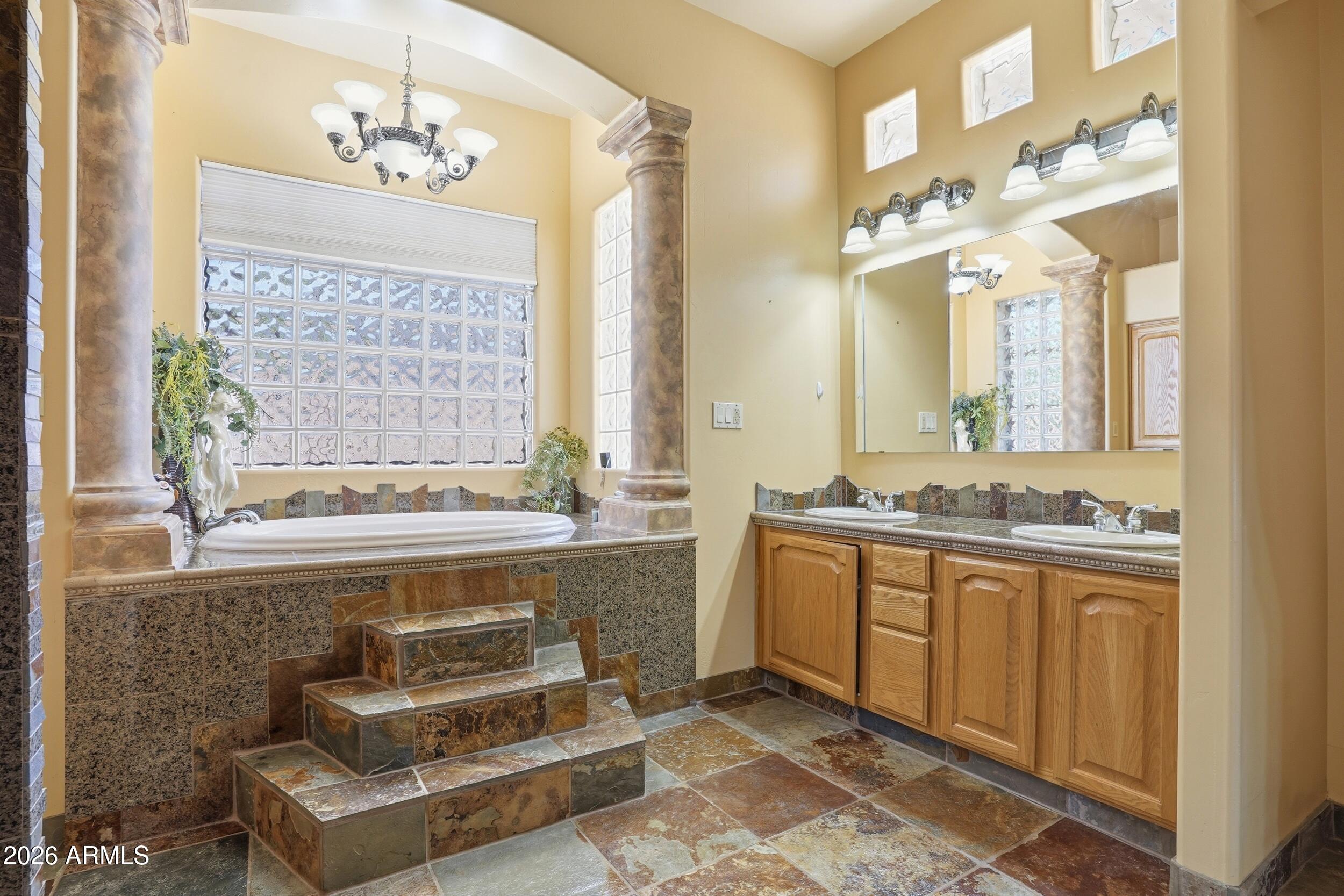 6334 East Albany Street Mesa, AZ 85205 - Photo 30 of 72 a spacious bathroom with a double vanity sink large mirror and a bathtub