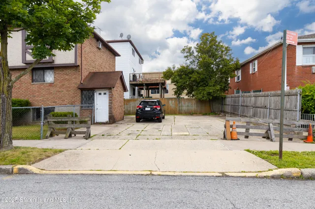 a front view of a building with cars parked