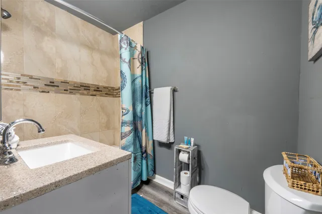 a bathroom with a granite countertop shower a mirror and a sink