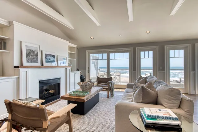 a living room with furniture fireplace and a large window