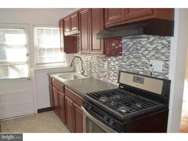 a kitchen with granite countertop a stove and a sink