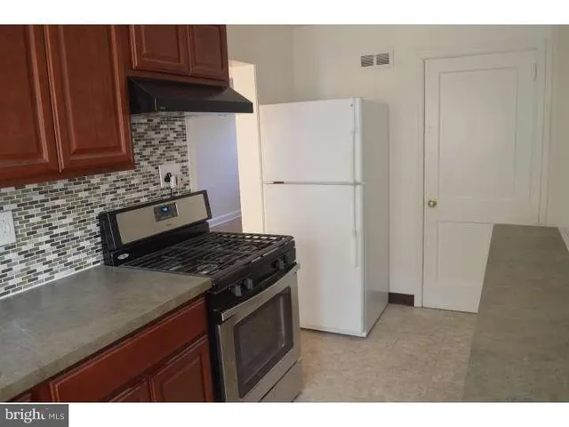 a kitchen with stainless steel appliances granite countertop a refrigerator stove and sink
