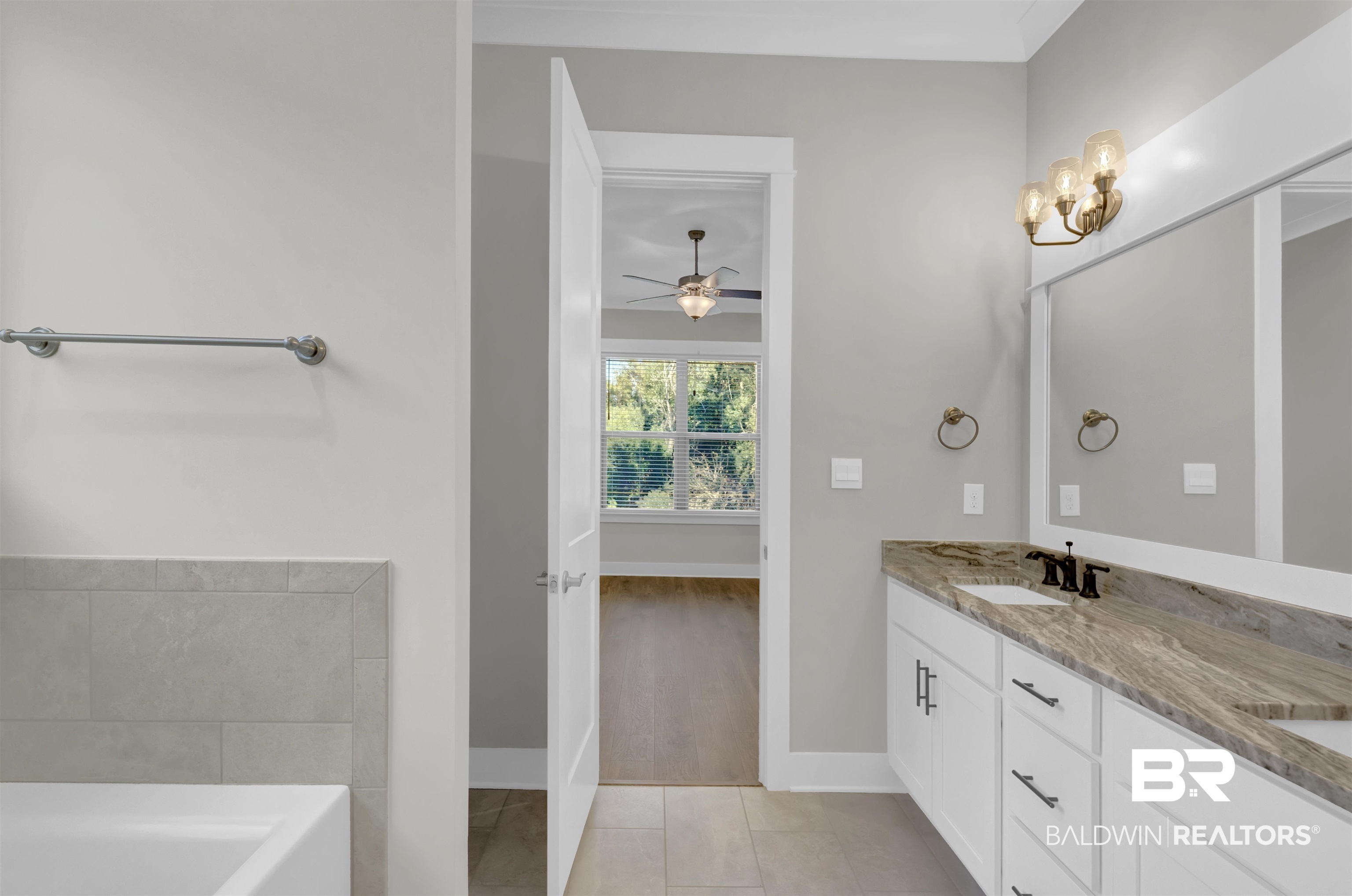 571 Morning Mist Way Fairhope, AL 36532 - Photo 24 of 47 Full bathroom with double vanity, light tile patterned floors, a tub to relax in, a ceiling fan, and a chandelier