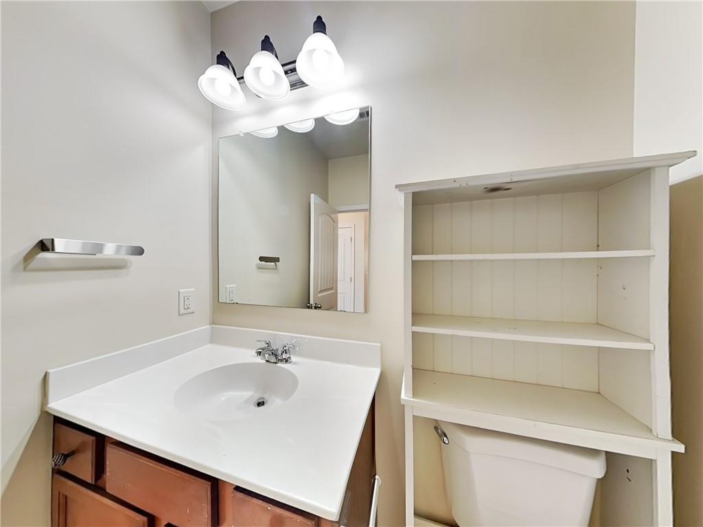 7770 Harbison Hollow Lane Suwanee, GA 30024 - Photo 17 of 25 a bathroom with a sink a mirror and a toilet