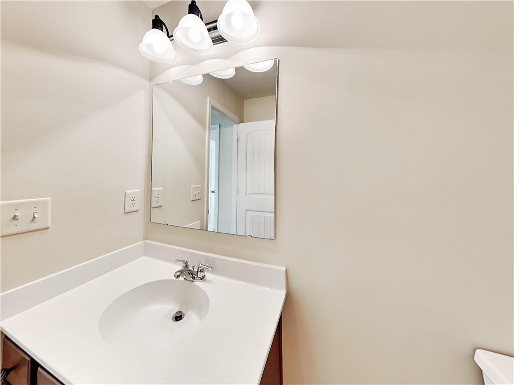 7770 Harbison Hollow Lane Suwanee, GA 30024 - Photo 21 of 25 a bathroom with a sink and a mirror