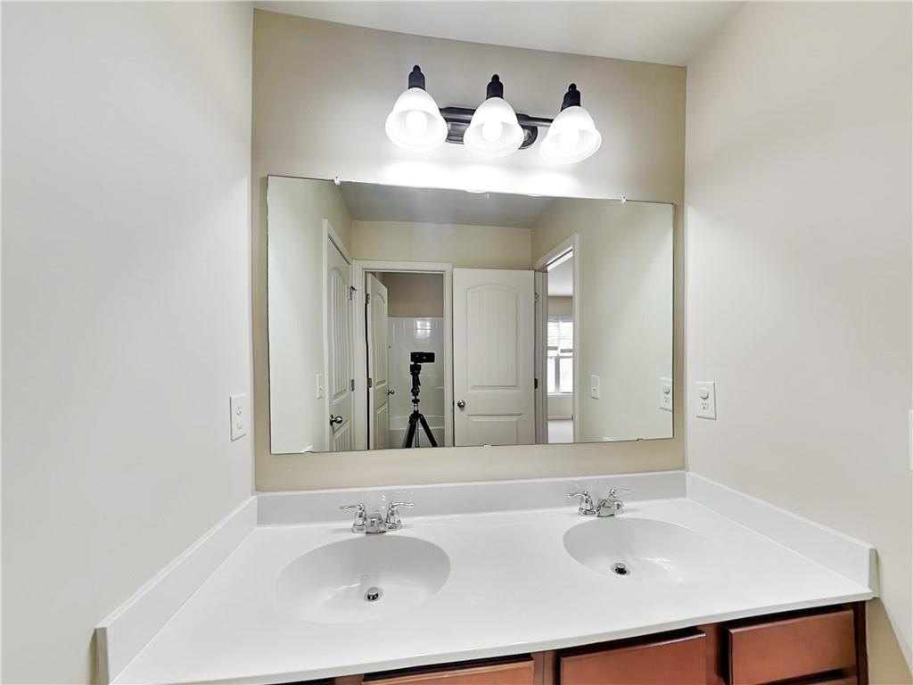 7770 Harbison Hollow Lane Suwanee, GA 30024 - Photo 23 of 25 a bathroom with a sink and a mirror