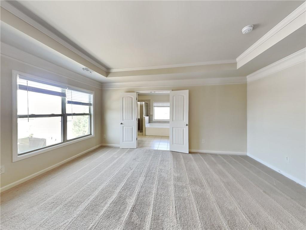 7770 Harbison Hollow Lane Suwanee, GA 30024 - Photo 7 of 25 a view of an empty room with a window and wooden floor