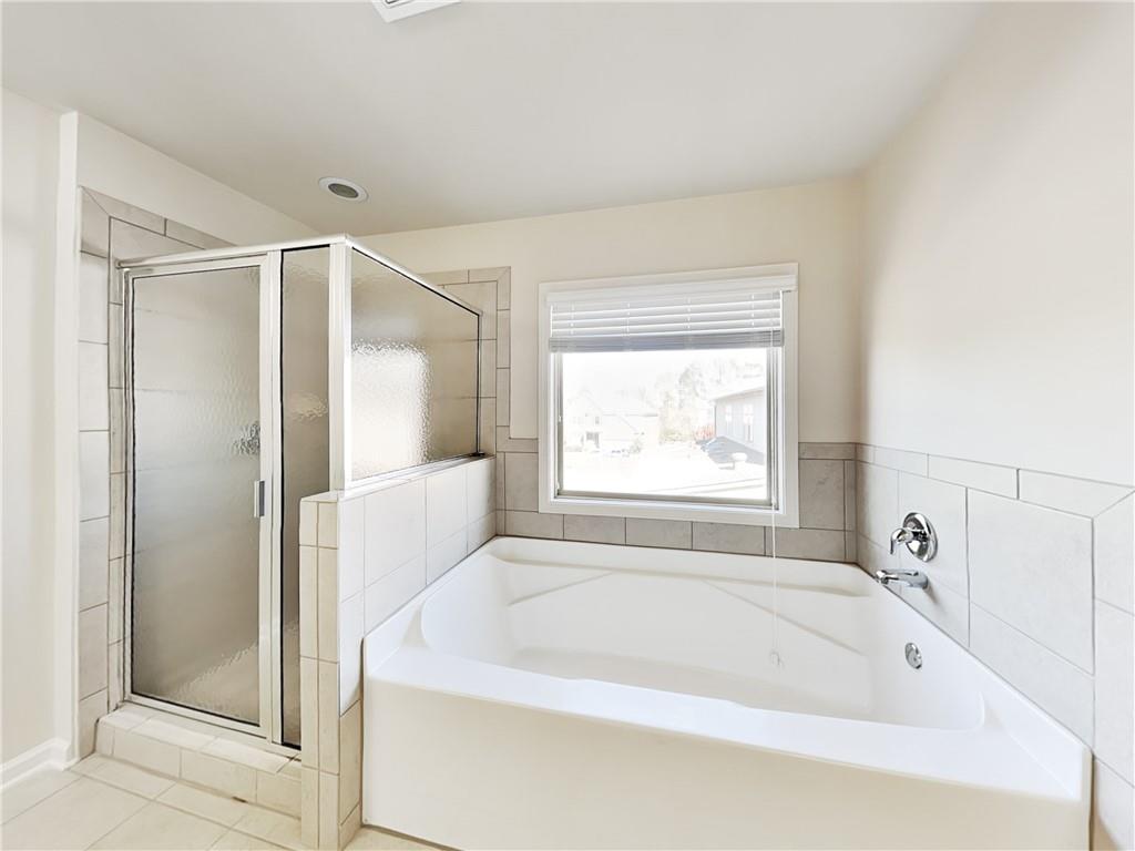 7770 Harbison Hollow Lane Suwanee, GA 30024 - Photo 9 of 25 a bathroom with a bathtub and a shower