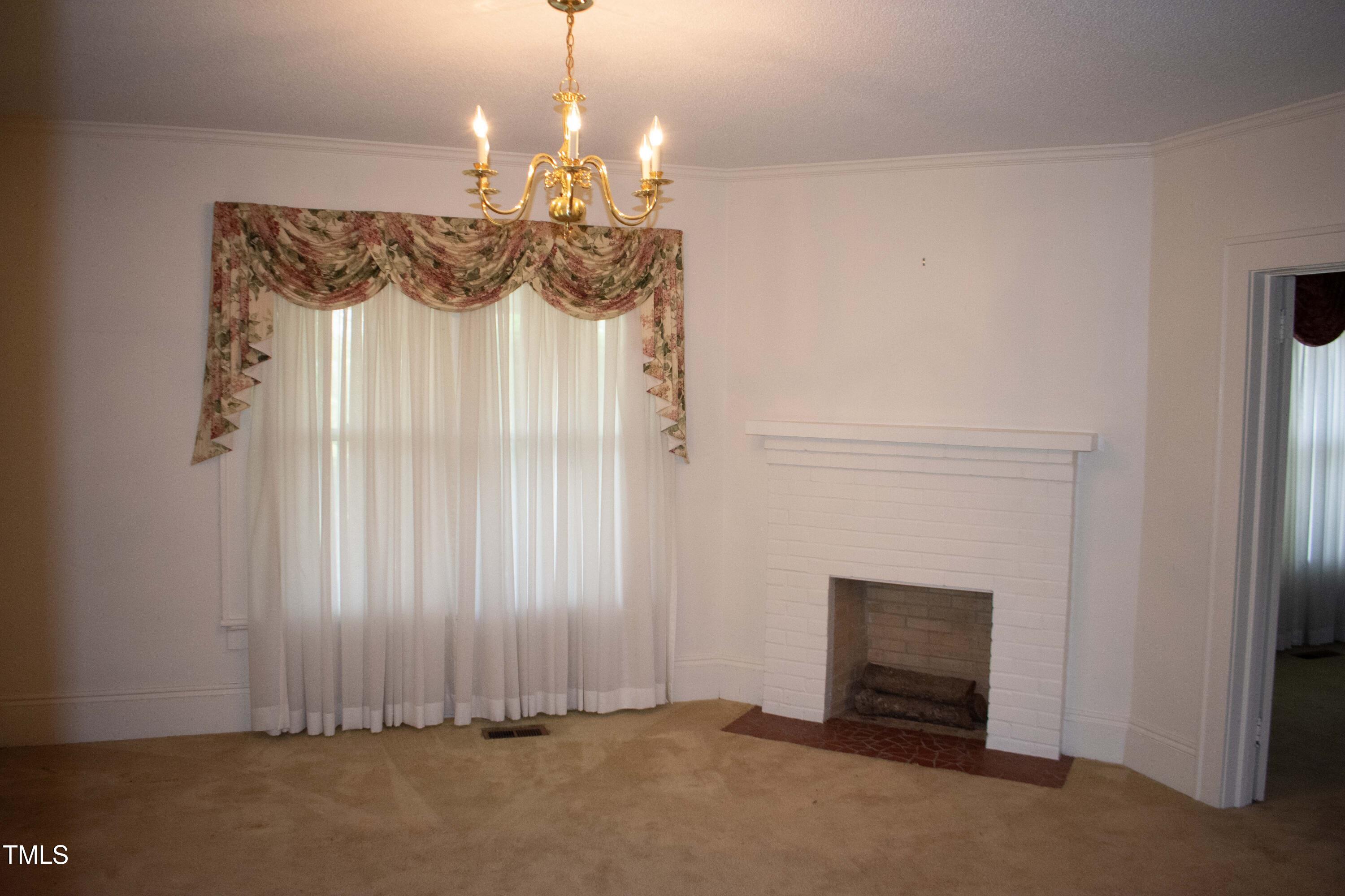 2024 Zebulon Road Zebulon, NC 27597 - Photo 14 of 16 a view of a livingroom with a chandelier and fireplace