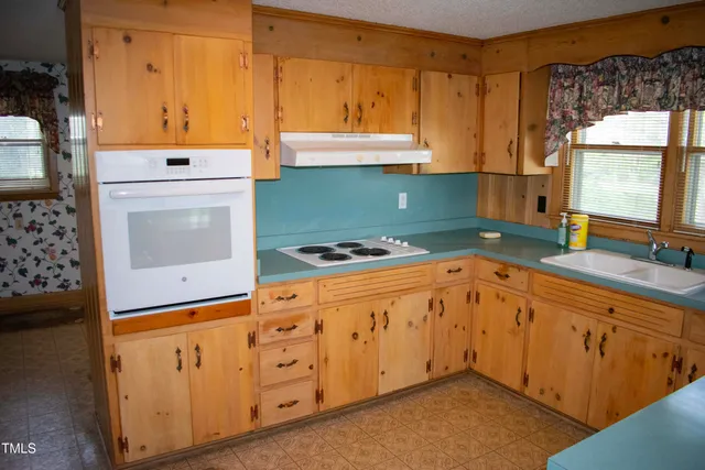 a kitchen with granite countertop cabinets a sink a window and stainless steel appliances