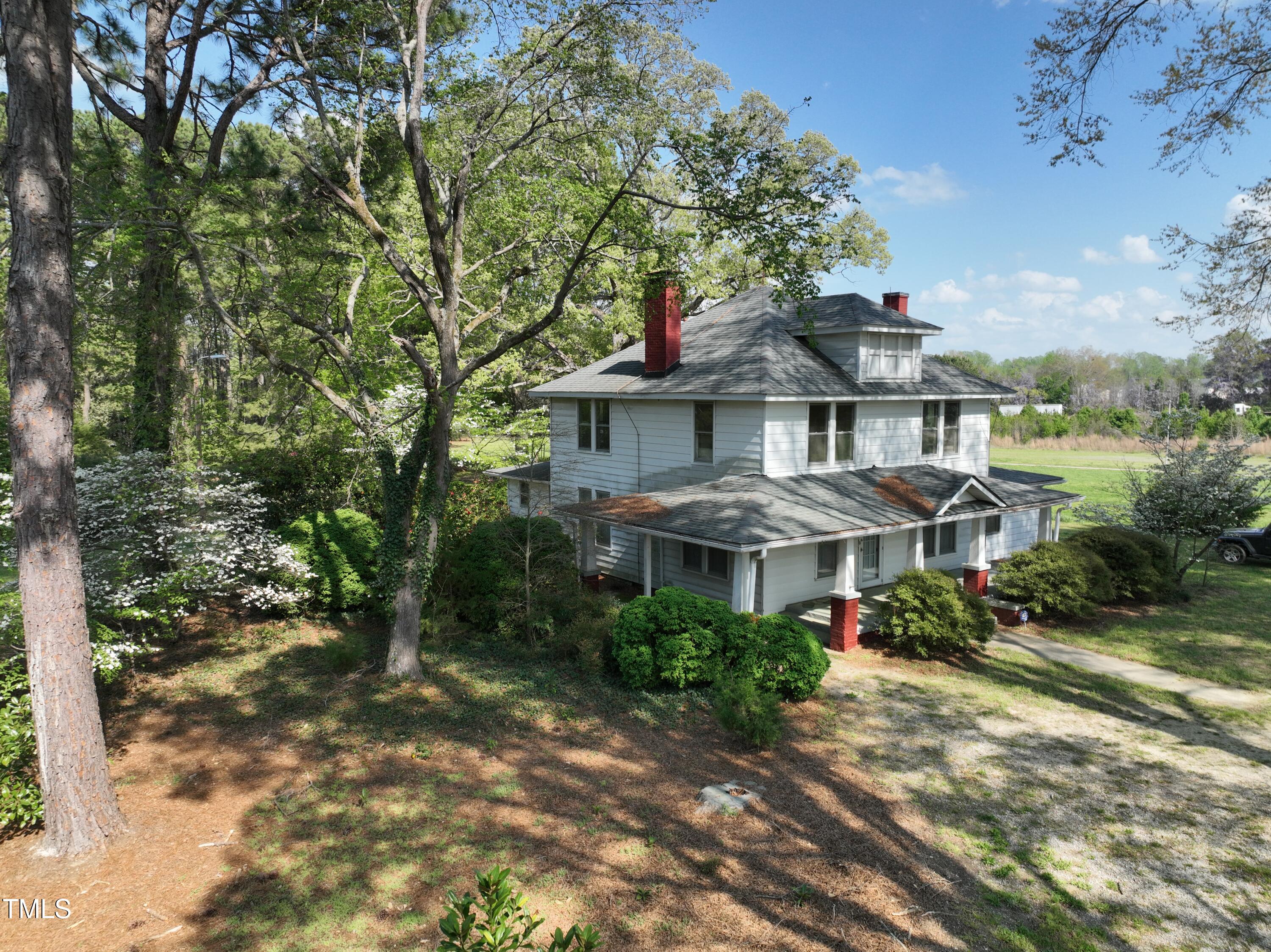 2024 Zebulon Road Zebulon, NC 27597 - Photo 8 of 16 a view of a white house with a yard plants and large tree