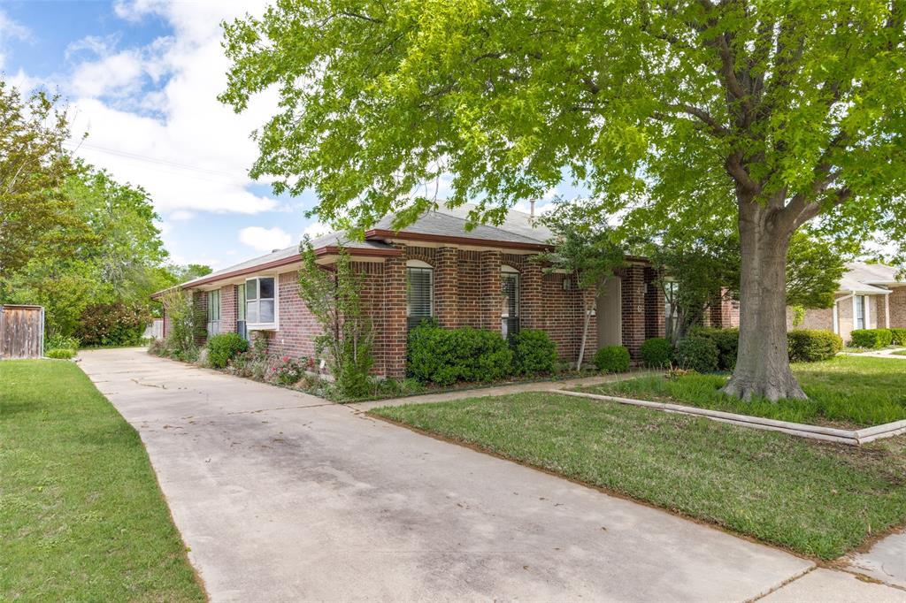 a front view of a house with a yard and an trees