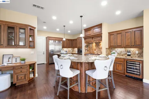 a kitchen with kitchen island a counter top space a sink stainless steel appliances and cabinets