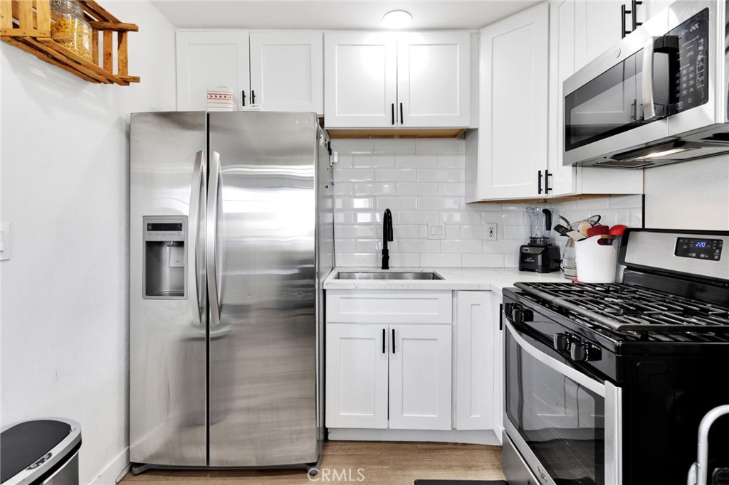 15109 Anacapa Road Victorville, CA 92392 - Photo 19 of 40 a kitchen with stainless steel appliances granite countertop a stove and a refrigerator