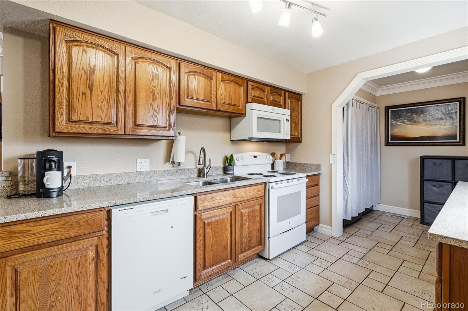 9280 Wigham Street Thornton, CO 80229 - Photo 11 of 34 a kitchen with a sink stove and cabinets