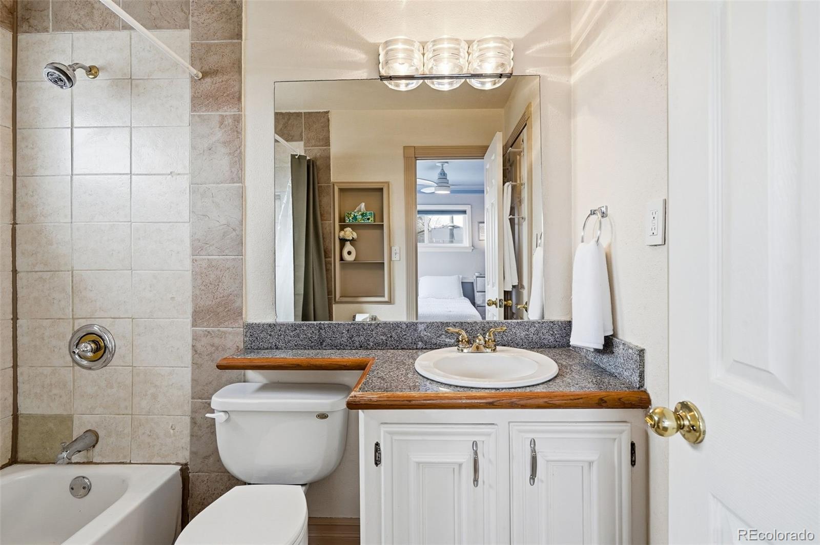 9280 Wigham Street Thornton, CO 80229 - Photo 18 of 34 a bathroom with a granite countertop sink a toilet and shower