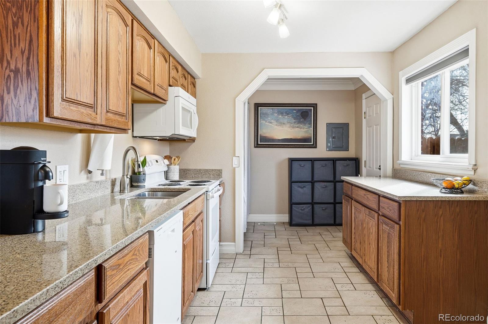 9280 Wigham Street Thornton, CO 80229 - Photo 10 of 34 a kitchen with stainless steel appliances granite countertop a sink and cabinets
