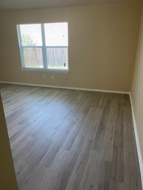 4753 Sea Ridge Drive Fort Worth, TX 76133 - Photo 11 of 16 an empty room with wooden floor and windows