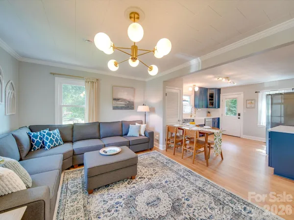 a living room with furniture a dining table and a large window