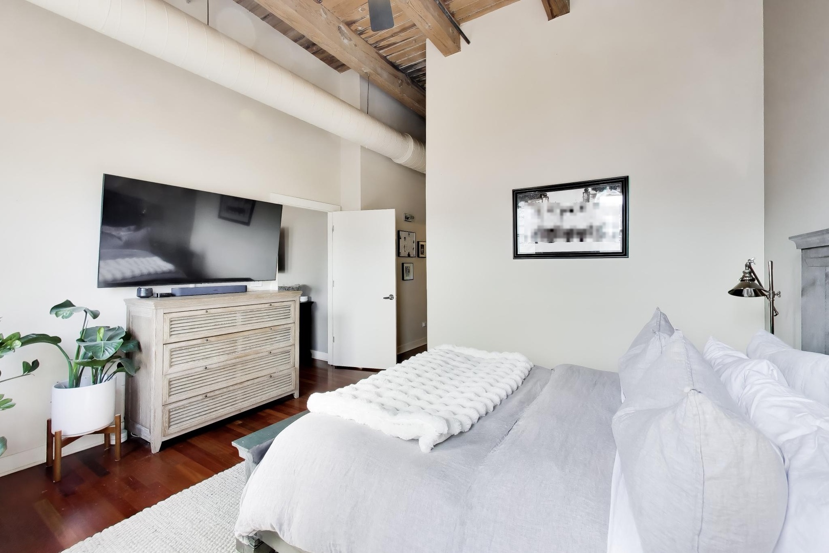 1050 West Hubbard Street, Unit 2F Chicago, IL 60642 - Photo 14 of 33 a bedroom with a bed and a flat screen tv