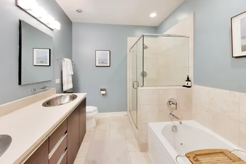 a bathroom with a tub sink and mirror