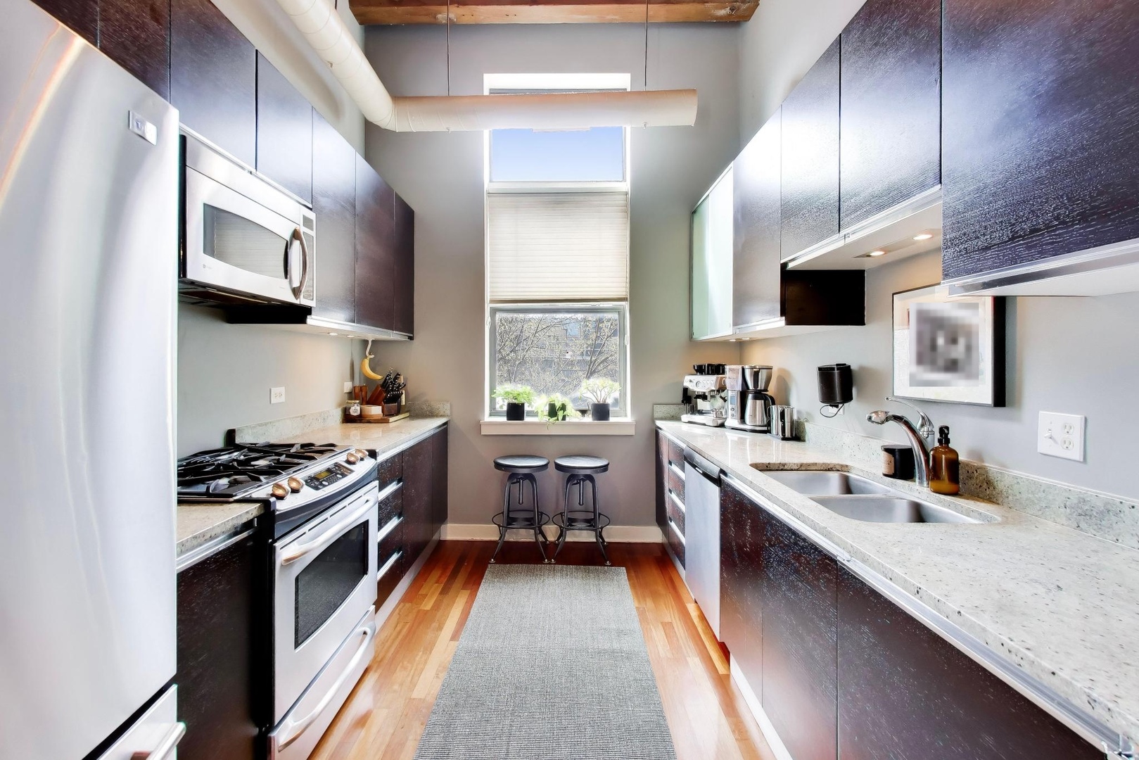 1050 West Hubbard Street, Unit 2F Chicago, IL 60642 - Photo 6 of 33 a kitchen with stainless steel appliances granite countertop a sink stove and refrigerator