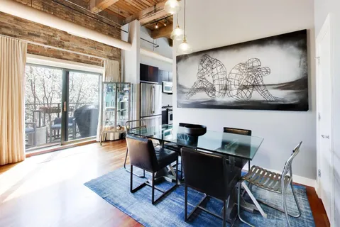 a view of a dining room with furniture a chandelier and wooden floor