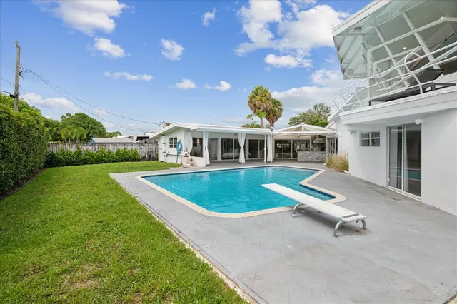 a view of a house with a swimming pool and yard