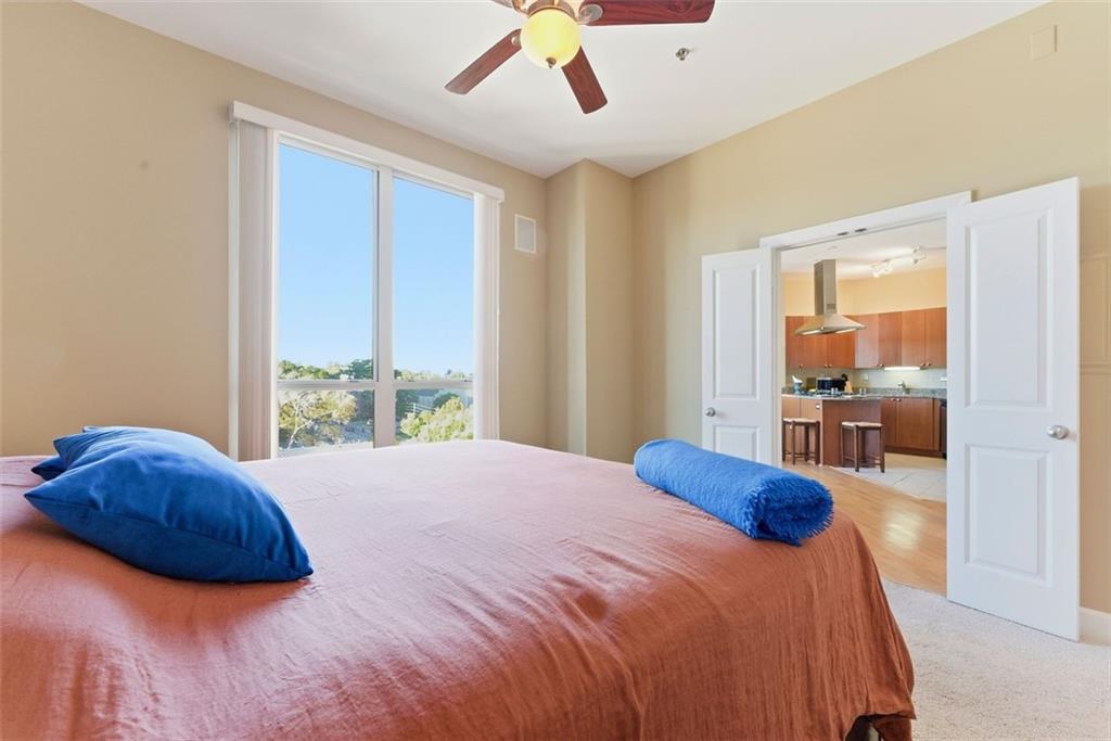 2626 Peachtree Road Northwest, Unit 1006 Atlanta, GA 30305 - Photo 12 of 19 a bedroom with a bed and glass walk in closet