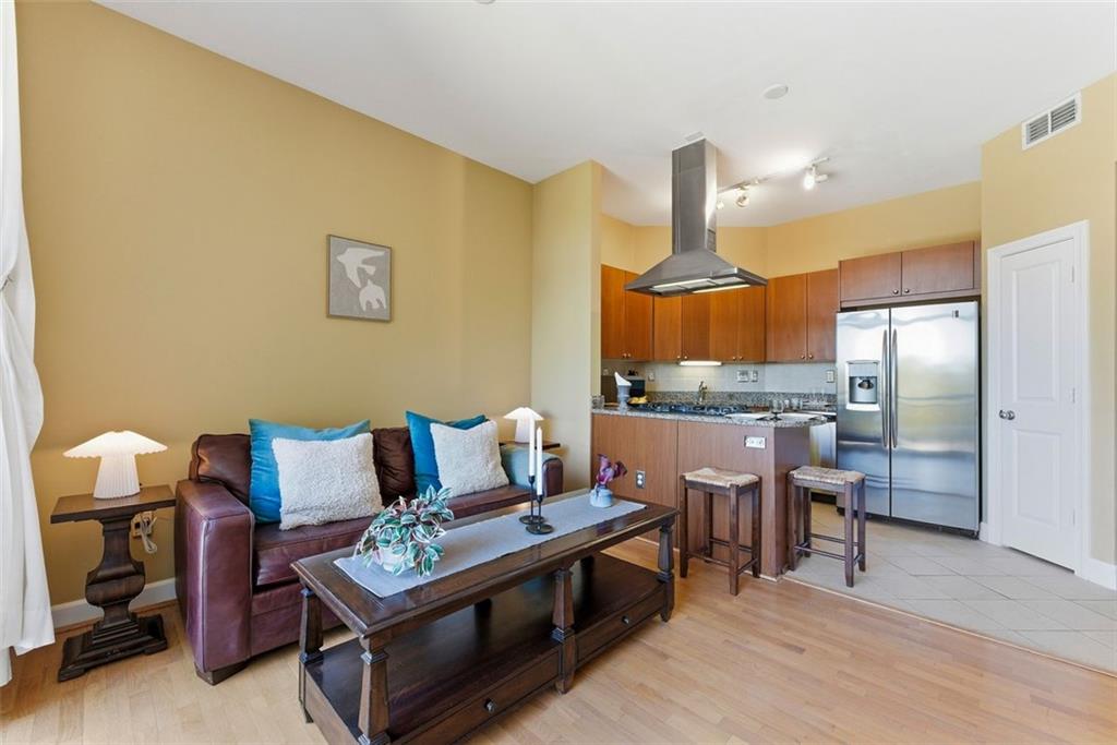 2626 Peachtree Road Northwest, Unit 1006 Atlanta, GA 30305 - Photo 2 of 19 a living room with stainless steel appliances kitchen island granite countertop furniture and a wooden floor