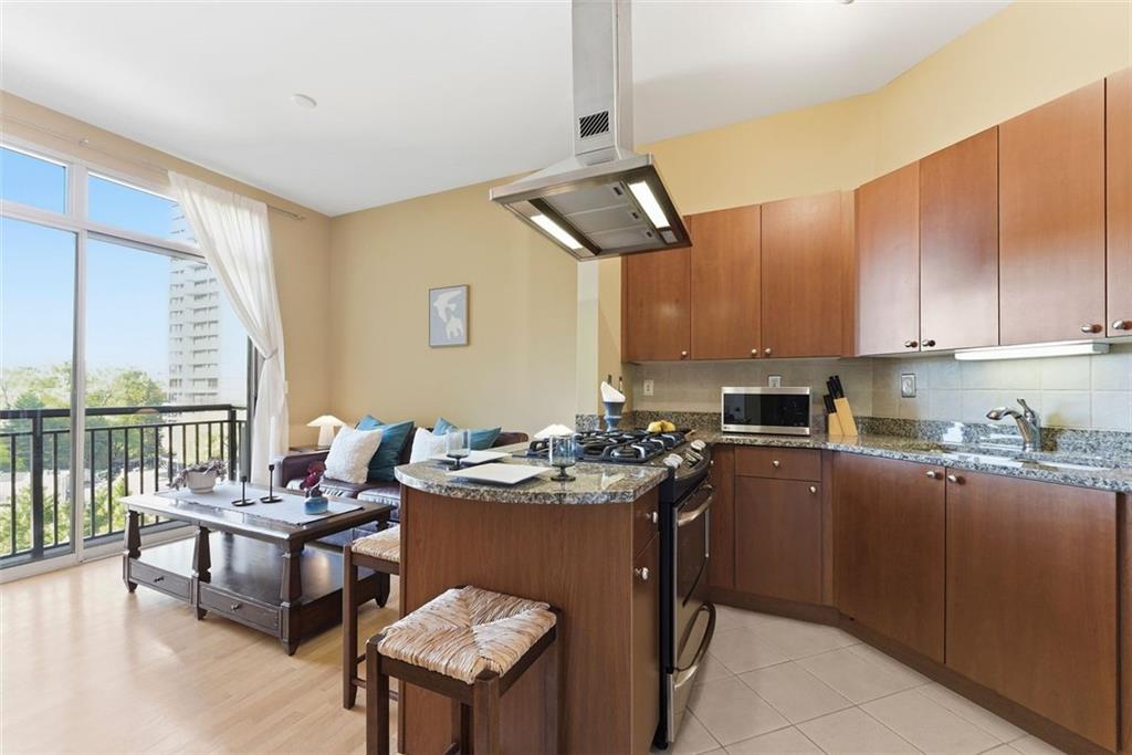 2626 Peachtree Road Northwest, Unit 1006 Atlanta, GA 30305 - Photo 7 of 19 a kitchen with a table chairs stove and cabinets