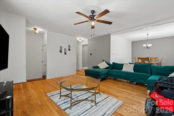 a living room with furniture a rug and a chandelier