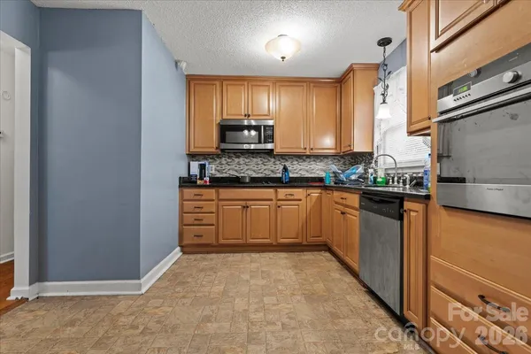 a kitchen with stainless steel appliances granite countertop a stove a sink dishwasher and a refrigerator