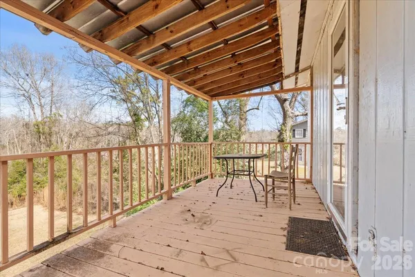 a view of two chairs and table in the balcony