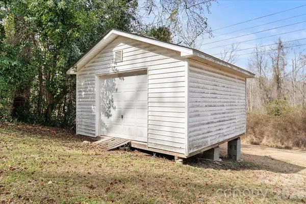 a view of a small house with a yard and garage