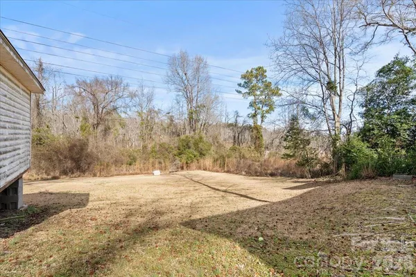 a view of backyard with wooden fence