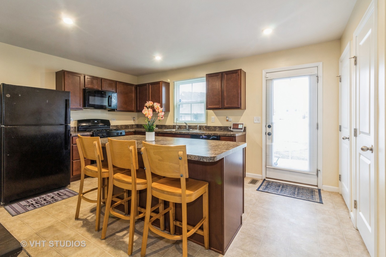 313 Pheasant Run Road Joliet, IL 60433 - Photo 7 of 24 a kitchen with stainless steel appliances granite countertop a stove a refrigerator a sink a dining table and chairs
