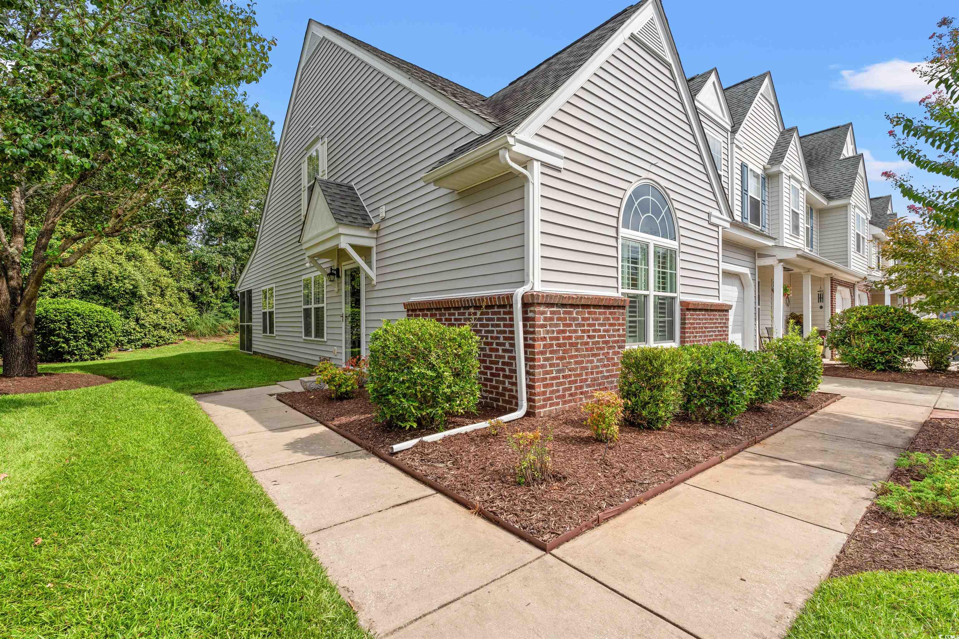 168 Wimbledon Way, Unit 168 Murrells Inlet, SC 29576 - Photo 2 of 27 View of side of property featuring brick siding, a lawn, and a shingled roof