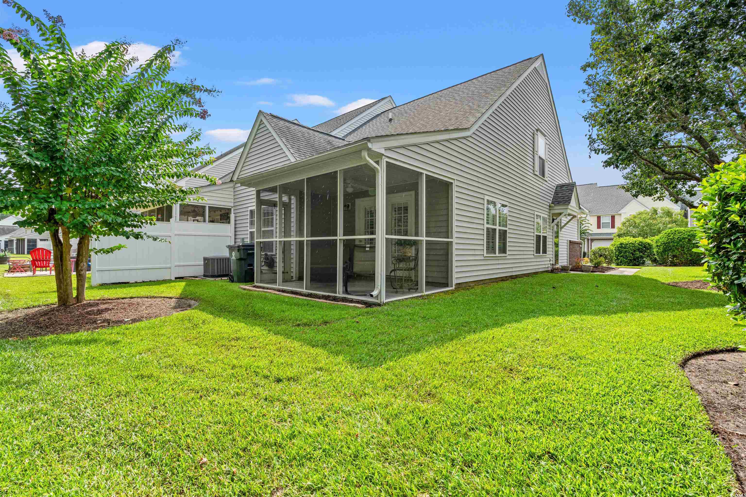 168 Wimbledon Way, Unit 168 Murrells Inlet, SC 29576 - Photo 24 of 27 Back of house featuring roof with shingles, a yard, and a sunroom