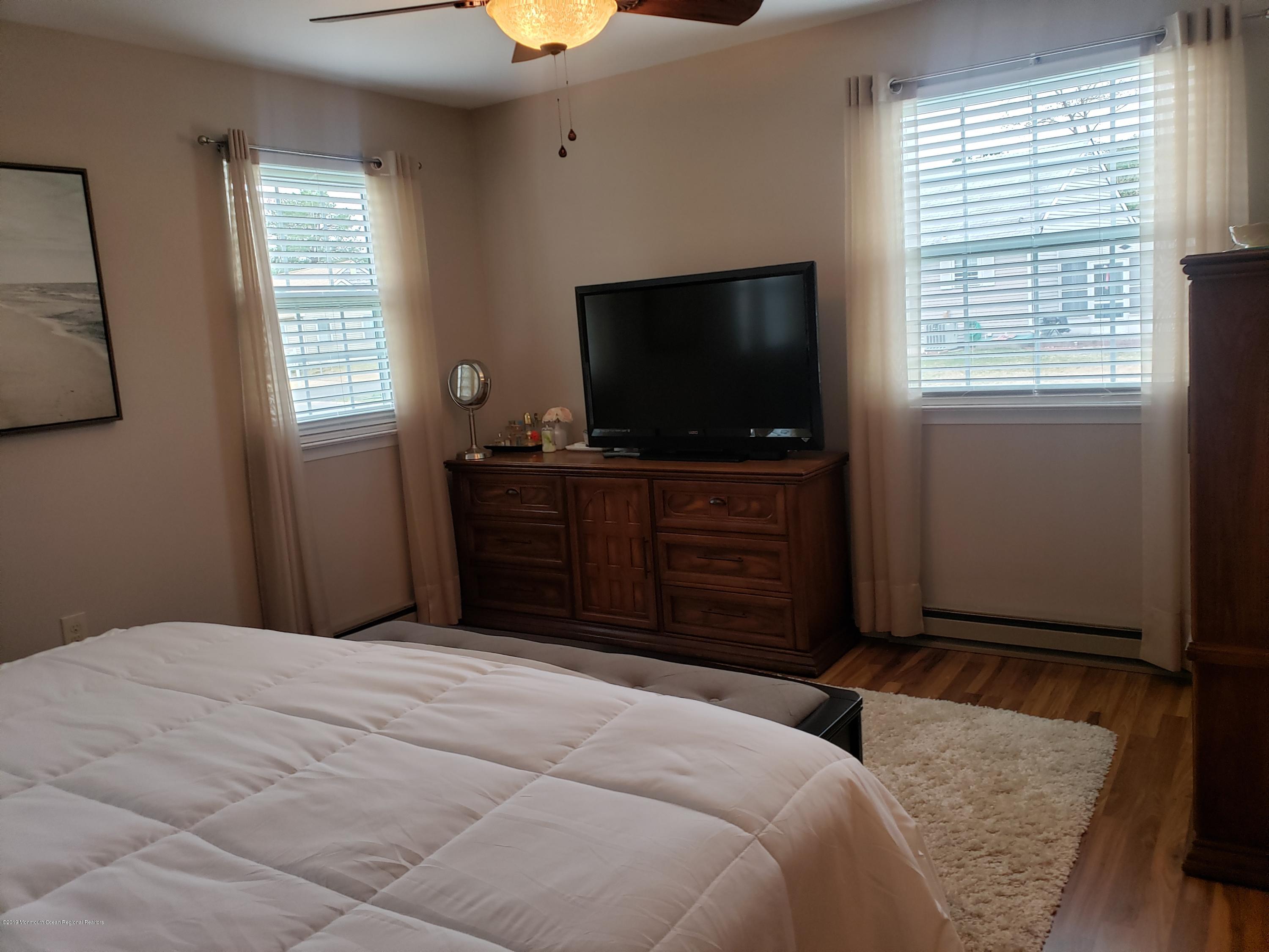 33 Mill Road, Unit 64 Whiting, NJ 08759 - Photo 19 of 23 a bedroom with a bed and a flat screen tv