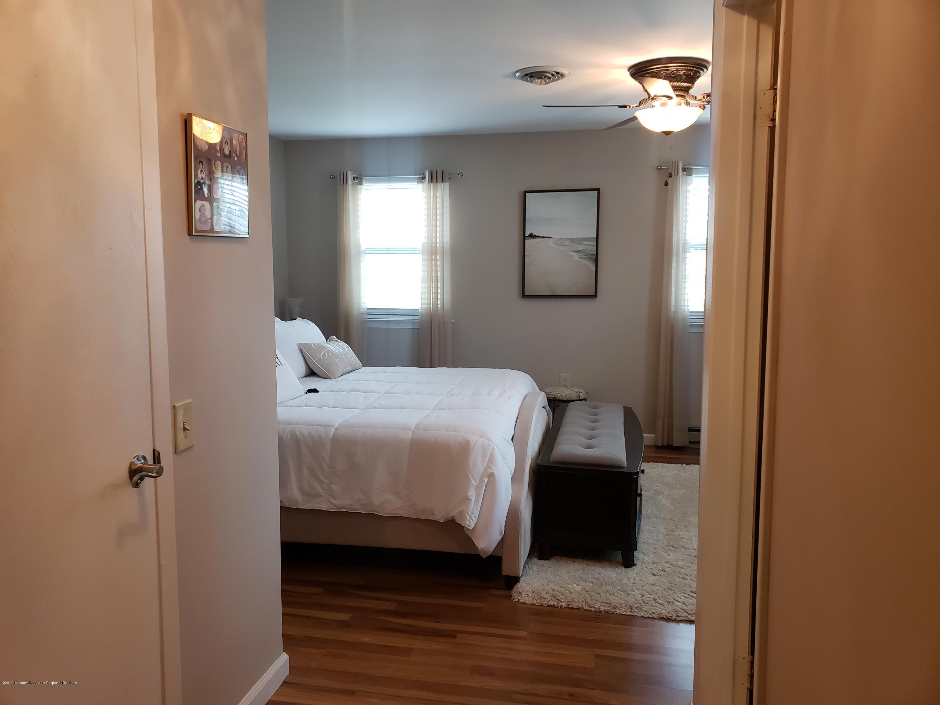 33 Mill Road, Unit 64 Whiting, NJ 08759 - Photo 5 of 23 a bedroom with a bed and wooden floor